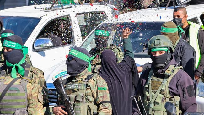 A woman throws confetti as Hamas fighters prepare to hand over four Israeli hostages to a Red Cross team at a square in Gaza City. Picture: AFP