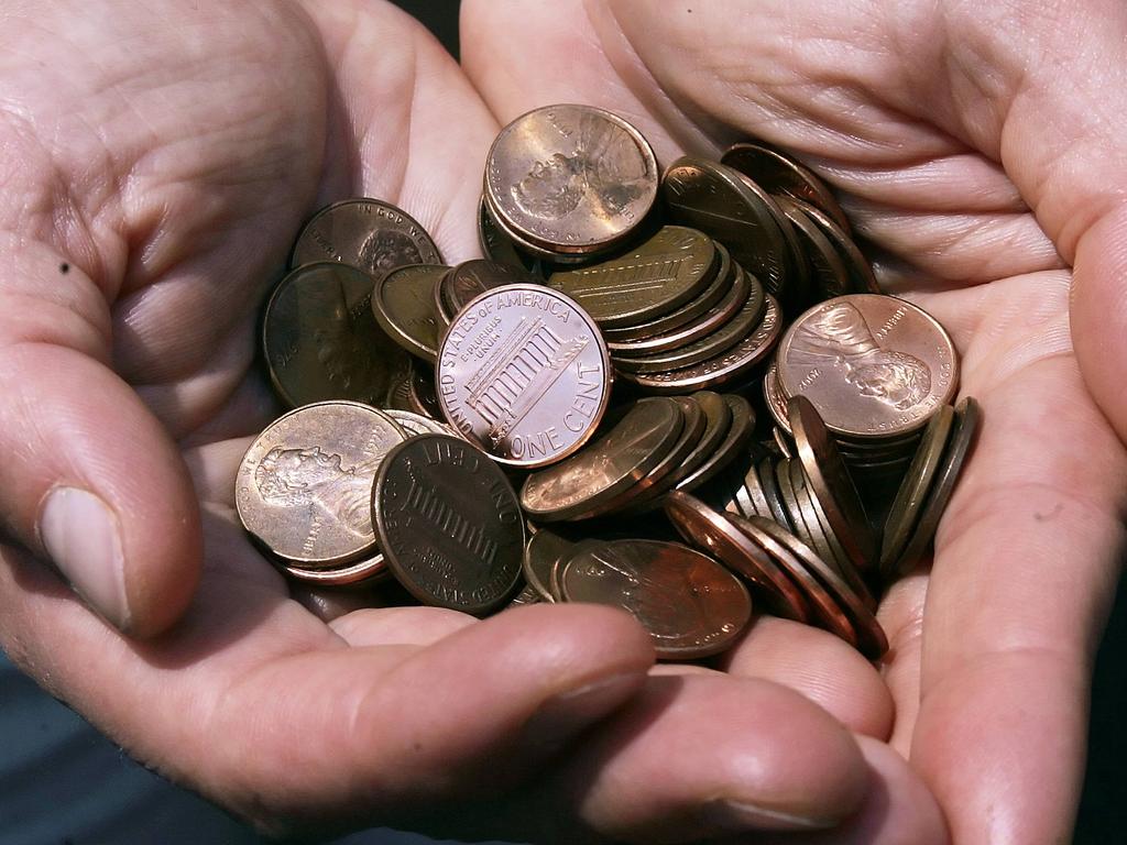 A man holds a handful of pennies in Washington, DC, after US President Donald Trump said the one cent coin would be cut to reduce government spending. One cent coins were phased out of Australian currency 35 years ago. Picture: Jim Watson/AFP