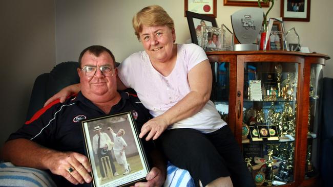 Howard and Lorraine Warner with a photo of son David playing cricket in his junior days as they sit beside a cabinet full of his trophies, at their Matraville home in Sydney.