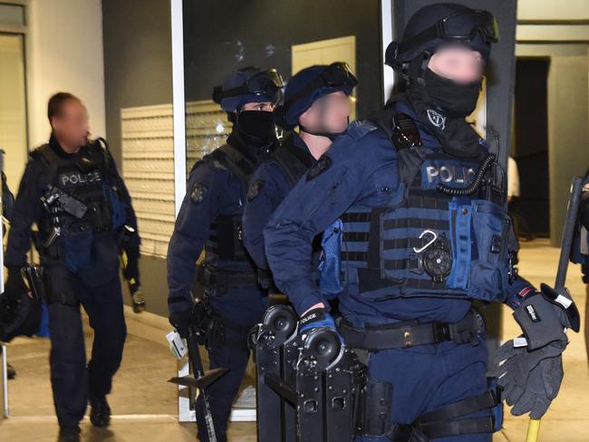 Police Critical Incident Response Team members leave flats in Carlton. Picture: Tony Gough