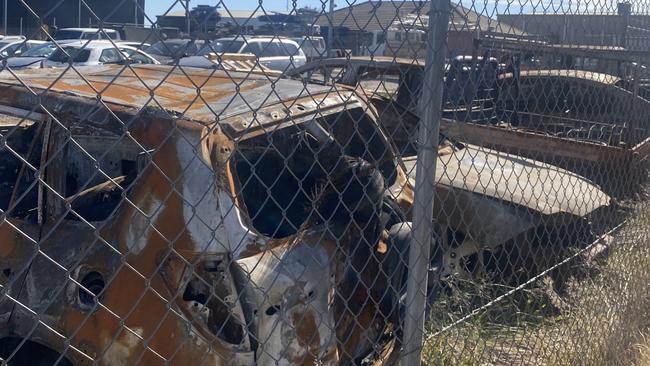 Two men have been charged with destroying property by fire after allegedly torching nine cars in a storage facility.