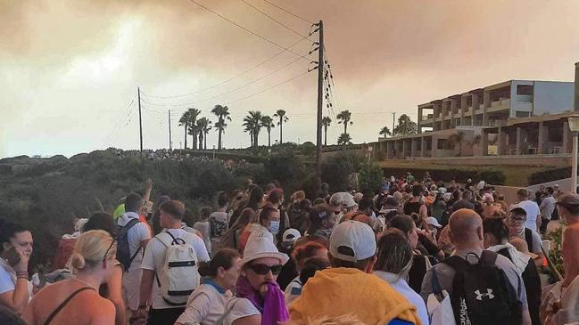 Tourists are evacuated from hotels during a wildfire on the Greek island of Rhodes. (Photo by STRINGER / Eurokinissi / AFP)