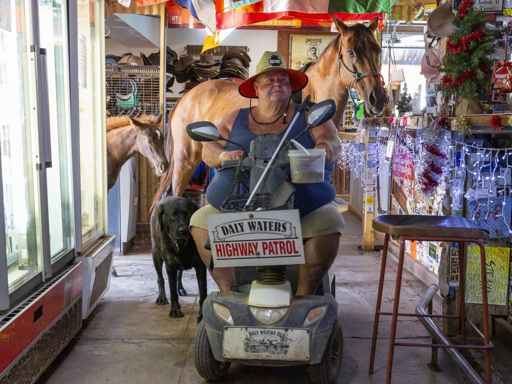 Daly Waters Historic Pub owner Tim Carter and his entourage of animals enter the pub to cool down. Picture: Floss Adams.