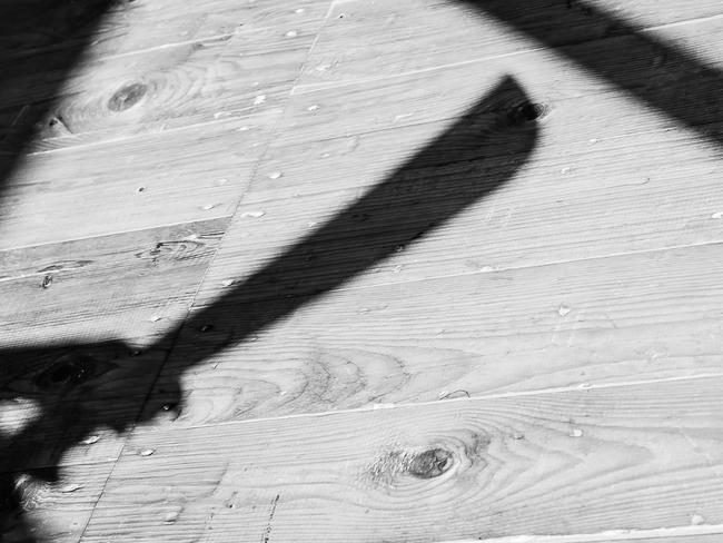 a shadow of a hand holding bid machete knife