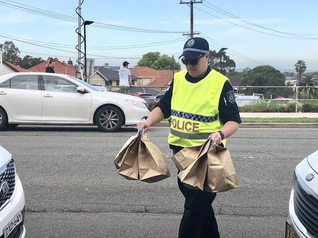 Officers from the Crash Investigation Unit with the paper bags of evidence from the scene.