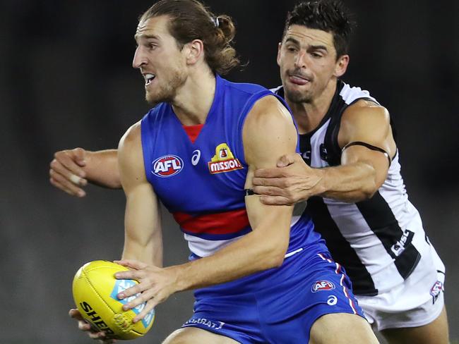 AFL Round 1. Western Bulldogs v Collingwood at Marvel Stadium..  21/03/2020.  Marcus Bontempelli of the Bulldogs looks to clear as Scott Pendlebury of the Magpies tackles   . Pic: Michael Klein