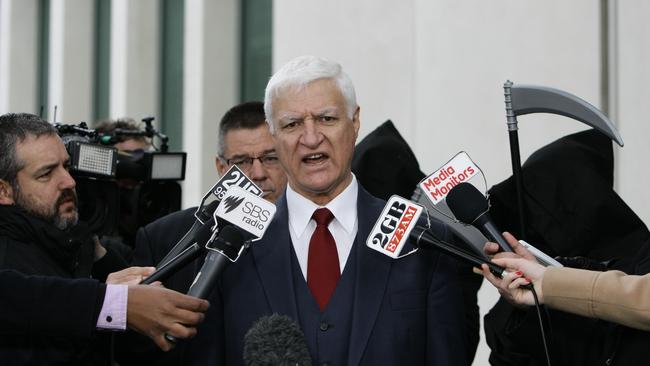 Bob Katter arrives with people dressed as the grim reaper at Parliament House.