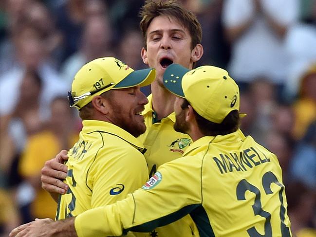 Australia's paceman Mitchell Marsh (R) celebrates with teammates Aaron Finch and Glenn Maxwell (R) after dismissing England's batsman Gary Ballance (not pictured) during the Pool A 2015 Cricket World Cup match between Australia and England at the Melbourne Cricket Ground (MCG) on February 14, 2015. AFP PHOTO / Saeed Khan --IMAGE RESTRICTED TO EDITORIAL USE - STRICTLY NO COMMERCIAL USE-