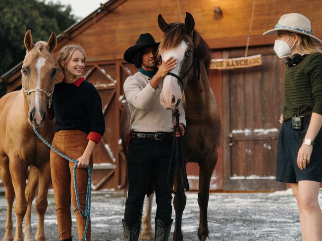 Actors Mercy Cornwall and Jordi Webber with their horses talking to director Rihannon Bannenberg on the set of Mistletoe Ranch at Alsace Polo Club in the hinterland. Picture: Supplied.