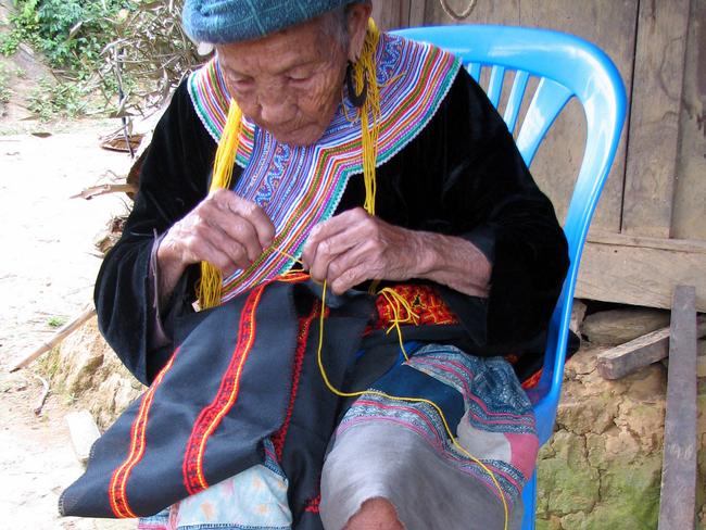 A Vietnamese woman embroidering traditional fabric.