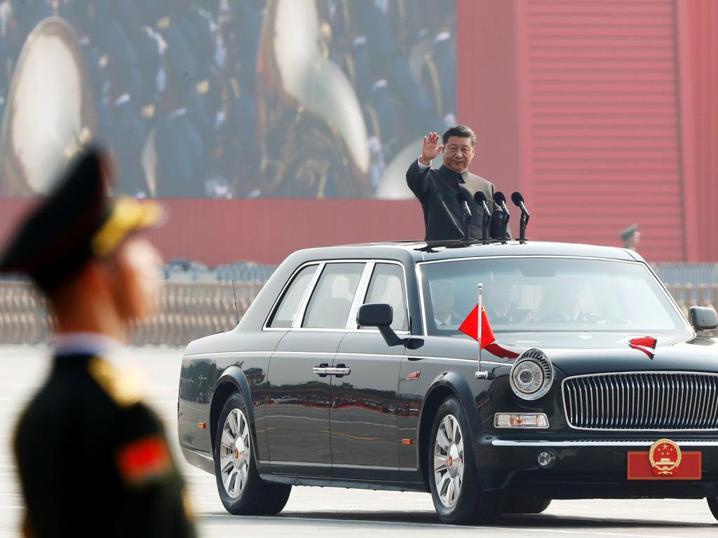 Chinese President Xi Jinping waves from a vehicle as he reviews troops at a military parade marking the 70th founding anniversary of People’s Republic of China. Picture: Thomas Peter/ Reuters