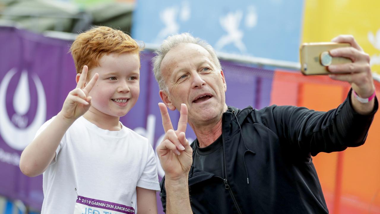 Jed ÒThe jetÓ Kennedy, 6, with grandfather Rob Ercoli take a photo for posterity at the finish of the Two Kilometre Junior Dash Pics Tim Marsden