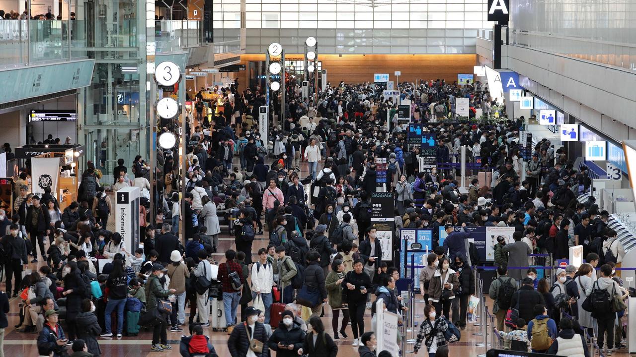 Travellers crowd the check-in area at terminal 2 at Tokyo International Airport on January 3 during flight delays. Picture: JIJI Press / AFP