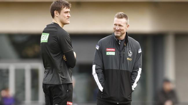 Magpies coach Nathan Buckley speaks with Darcy Moore, who could return this week.