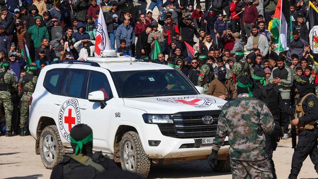 A Red Cross vehicle arrives in a square to pick up the hostages while Hamas fighters secure the area before releasing them. Picture: AFP