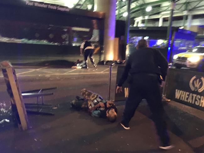 Armed police stand over two suspects shot at the scene of a terror attack outside Borough Market in central London. Picture: Gabriele Sciotto/AFP