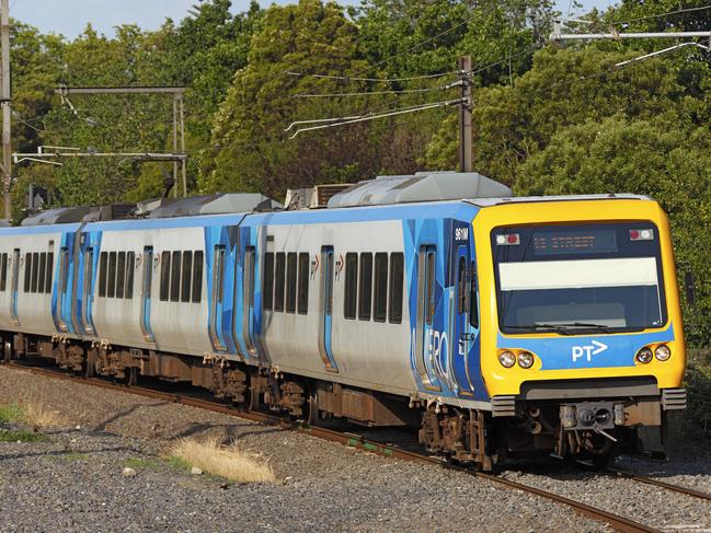 Melbourne, Australia – December 3, 2013: A Melbourne Metro electric commuter train slows to stop at a suburban station on the Belgrave/Lilydale line while heading to the city centre at the end of afternoon rush hour.