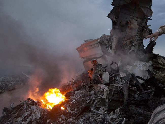 People inspect the crash site of a passenger plane near the village of Grabovo, Ukraine, Thursday, July 17, 2014. Ukraine said a passenger plane carrying 295 people was shot down Thursday as it flew over the country, and both the government and the pro-Russia separatists fighting in the region denied any responsibility for downing the plane. (AP Photo/Dmitry Lovetsky)