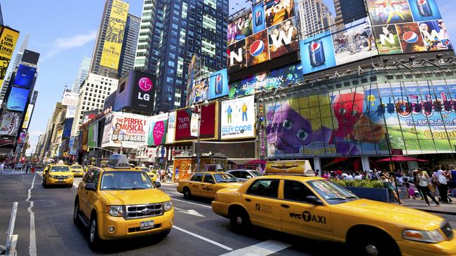 NEW YORK CITY - CIRCA JULY 2012: Yellow taxi cabs crossing Times Square with crowds of people and lots of advertising on July, 2012 in Manhattan, New York City. USA