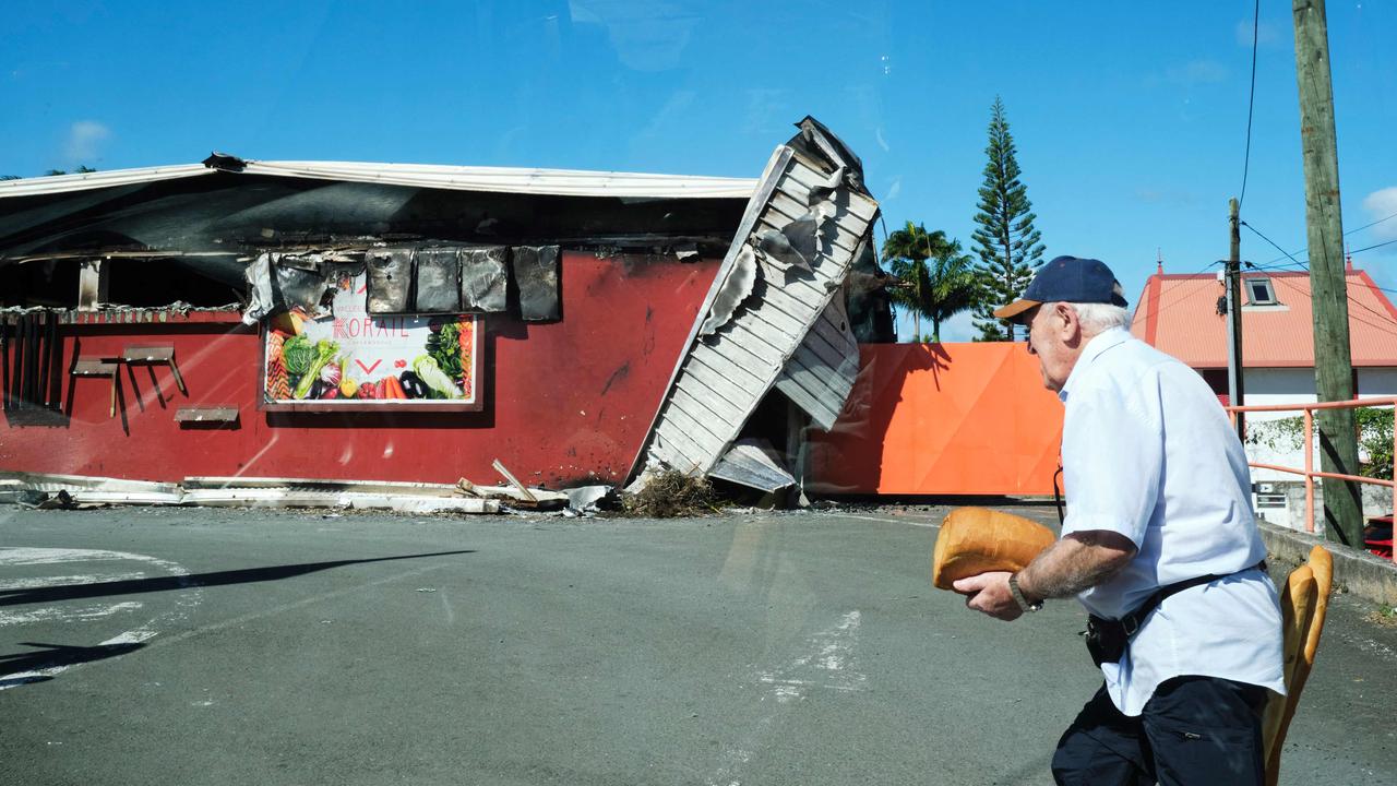 A man walks past a damaged supermarket in Noumea, France's Pacific territory of New Caledonia, on May 24. Picture: Theo Rouby / AFP