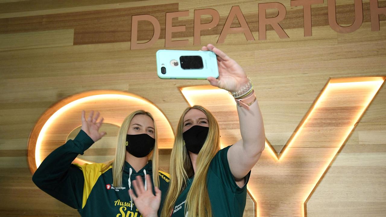 Australian softball players Shannon Keevers (L) and Ellen Roberts wave while on a video chat.