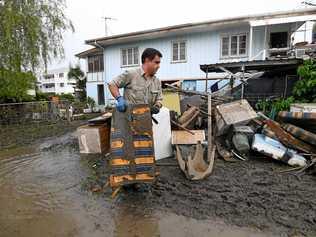 A man helps total strangers to remove flood-damaged items from their home in the suburb of Rosslea in Townsville, Thursday, February 7, 2019. Residents have begun cleaning up after days of torrential rain and unprecedented water releases from the city's swollen dam, sending torrents of water down the Ross River and into the city, swamping roads, yards and homes. (AAP Image/Dan Peled) NO ARCHIVING. Picture: DAN PELED