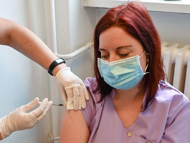 A nurse (R) gets her second dose of the Pfizer-BioNTech vaccine against the novel coronavirus / COVID-19 in a medical centre of Budapest on January 28, 2021, as the second round of vaccination among health workers continues. - Hungary extended a coronavirus state of emergency for 90 days  and partial lockdown measures until March 1, and it would issue a decree licensing any vaccine already used on a million people. (Photo by ATTILA KISBENEDEK / AFP)