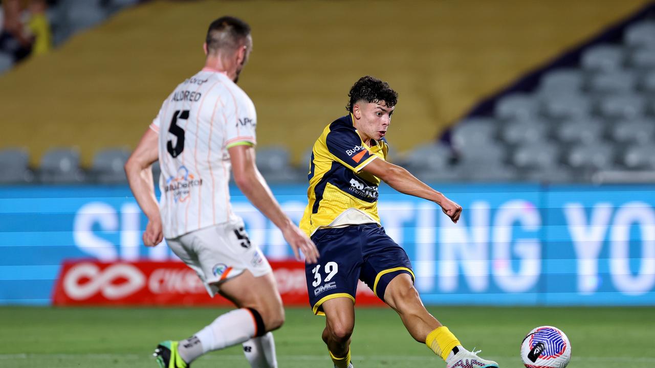 Mariners goalscorer Miguel Di Pizio (right) shoots as Roar captain Tom Aldred approaches. Picture: Brendon Thorne/Getty Images