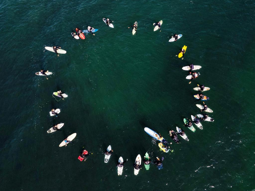 Surfers gather in at San Miguel Beach in Mexico to honour Australian brothers Jake and Callum Robinson and their American friend Jack Carter Rhoad, whose bodies were discovered after being shot and disposed of in a well. Picture: Guillermo Arias/AFP