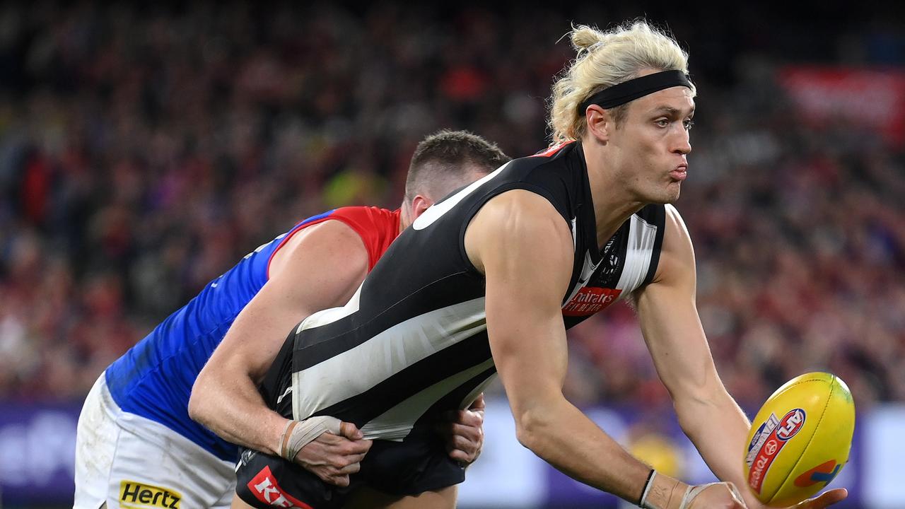 Darcy Moore handballs as Tom McDonald attempts a tackle. Picture: Quinn Rooney/Getty Images