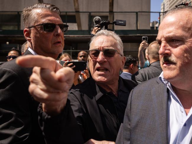 Actor Robert De Niro, center, points to a supporter of former US President Donald Trump, not pictured, as he departs following a news conference outside Manhattan criminal court in New York, US, on Tuesday, May 28, 2024. Former US President Donald Trump faces 34 felony counts of falsifying business records as part of an alleged scheme to silence claims of extramarital sexual encounters during his 2016 presidential campaign. Photographer: Yuki Iwamura/Bloomberg via Getty Images