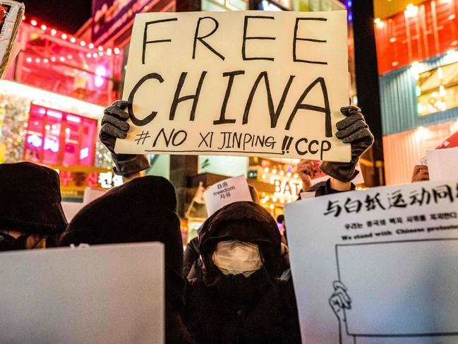 EDITORS NOTE: Graphic content / TOPSHOT - A group of protesters hold a gathering in Seoul on November 30, 2022, in support of demonstrations held in China over Beijing's Covid-19 restrictions. (Photo by Anthony WALLACE / AFP)