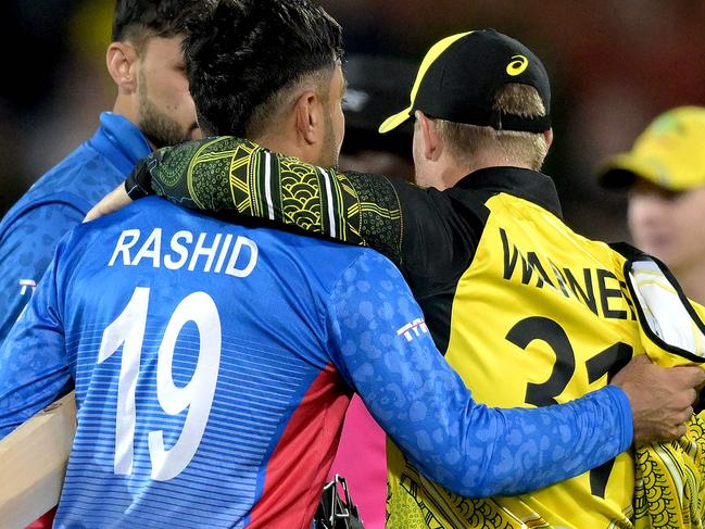 Australia's David Warner (R) embraces Afghanistan's Rashid Khan after the ICC men's Twenty20 World Cup 2022 cricket match between Australia and Afghanistan at Adelaide Oval on November 4, 2022 in Adelaide. (Photo by Brenton EDWARDS / AFP) / -- IMAGE RESTRICTED TO EDITORIAL USE - STRICTLY NO COMMERCIAL USE --