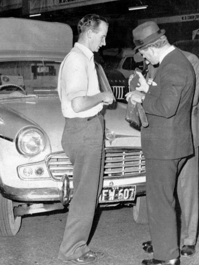 Police examine a shotgun seized in a swoop during the 1960s Victorian Market murders in Melbourne. Picture: HWT Library