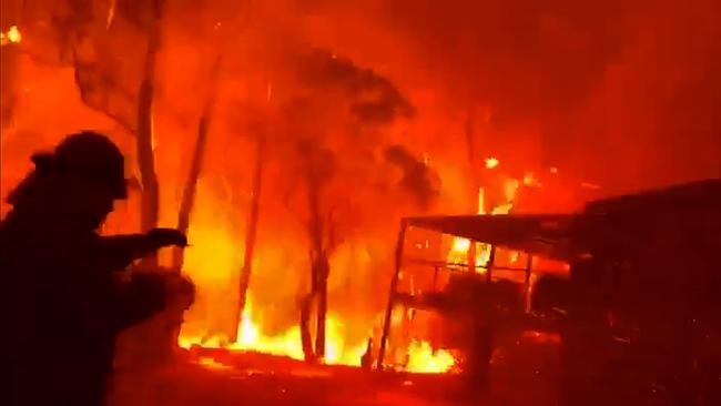 A firefighter is faced with monster flames while trying to save a home in Blackheath, in the Blue Mountains west of Sydney, on Sunday. Picture: NSWRFS