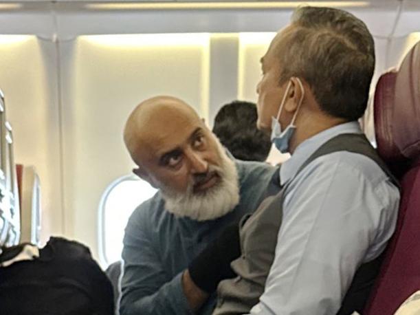 Then man (left) speaks to a fellow passenger.