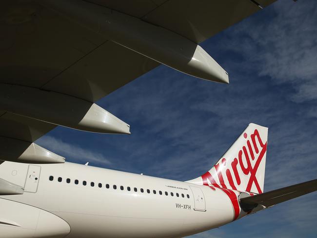 The Virgin Australia Holdings Ltd. logo is displayed on the tail of an Airbus SAS A330 aircraft at Sydney Airport in Sydney, Australia, on Monday, Aug. 17, 2015. Virgin Australia launched its new business-class suites for its A330 fleet. Photographer: Brendon Thorne/Bloomberg