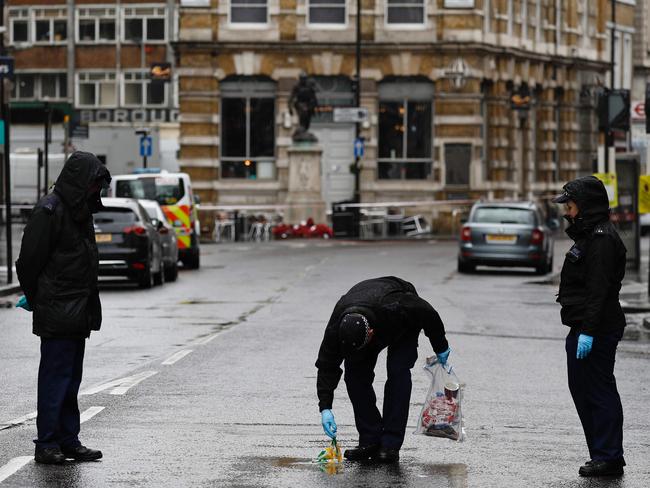 A Police officer carries an evidence bag as he works with colleagues on Borough High Street, close to Borough Market, in London. Picture: AFP / Odd ANDERSEN