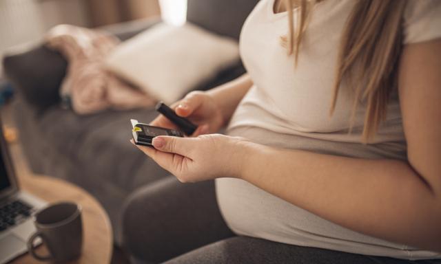 junge schwangere Frau kontroliert ihren Blutzucker in der Schwangerschaft