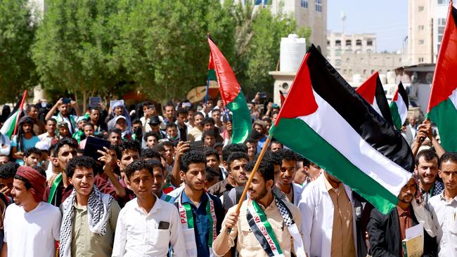 People wave the Palestinian flag as they march to show solidarity with the Palestinians of the West Bank and Gaza Strip. Picture: AFP