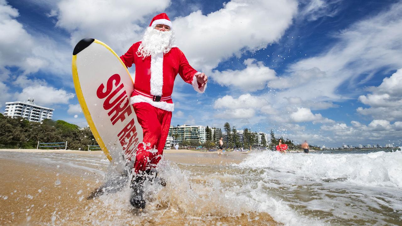 Father Christmas tests out the water temperature at the Sunshine Coast’s Mooloolaba Beach where he will be making a guest appearance on Christmas Eve before his mission begins. Picture: Lachie Millard