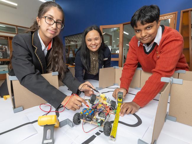 Suzanne Cory High School robotics and mathematics teacher Michelle Magalona in her classroom with members of her year 10 robotics class, Amnah Adnan and Akash Mahalanabis. Picture: Tony Gough