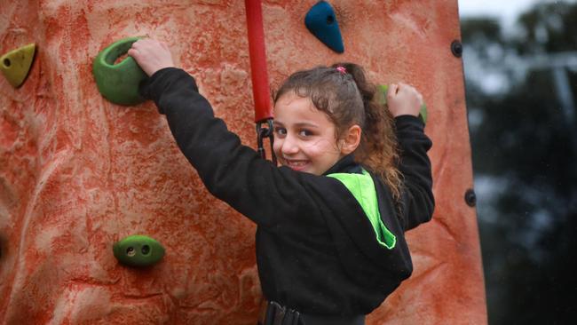 7 year old Siham Begdoun poses for photographs on a rock climbing tower in Rooty Hill. Rooty Hill. Wednesday, October 10th 2018. Western Sydney Community Housing Providers Mission Australia Housing, Evolve Housing and SGCH will come together for a School holiday event to participate in active healthy lifestyle choices and sporting activities. (AAP Image / Angelo Velardo)