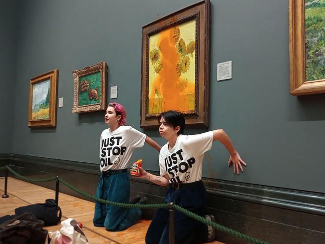 Anti-oil climate activists with their hands glued to the wall under Vincent van Gogh's "Sunflowers" after throwing tomato soup on the priceless painting at London’s National Gallery.