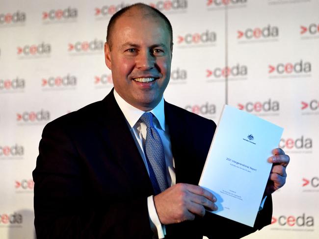 Australian treasurer Josh Frydenberg holds a copy of the 2021 Intergenerational Report in Melbourne on June 28, 2021. (Photo by William WEST / AFP)