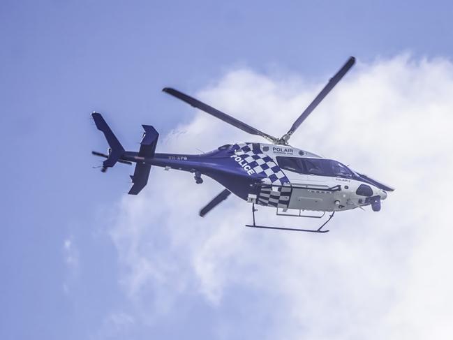 The PolAir 2 helicopter flies laps over Gilston in search of three alleged armed robbers on the loose. Photo: Luke Sorensen