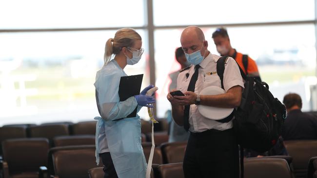 Temperature checks and police presence on arrival of QF529 from Brisbane. Picture: NCA NewsWire / Christian Gilles