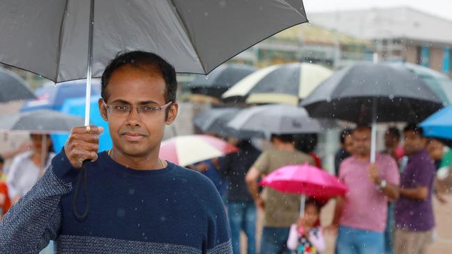 Rajesh Subramanian and other local residents of Schofield’s Akuna Vista estate brave the rain to protest against a proposal to rename the suburb Nirimba Marana. Picture: Angelo Velardo