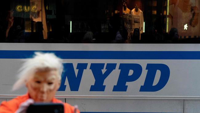 A person impersonating Donald Trump wearing an orange jumpsuit, gives a thumbs up in front of a New York Police Department bus outside Trump Tower in New York on Monday. Picture: AFP