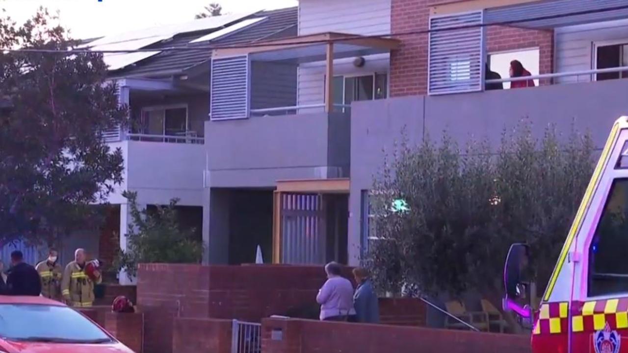 Neighbours gather outside as firefighters attend the scene of Paul Murphy’s burning flat. Picture: Channel 7